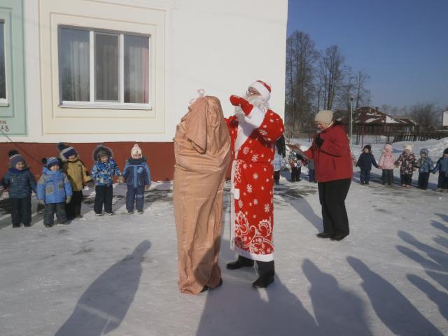 Фото с праздника Масленица. дед Мороз развязывает мешок с подарками.
